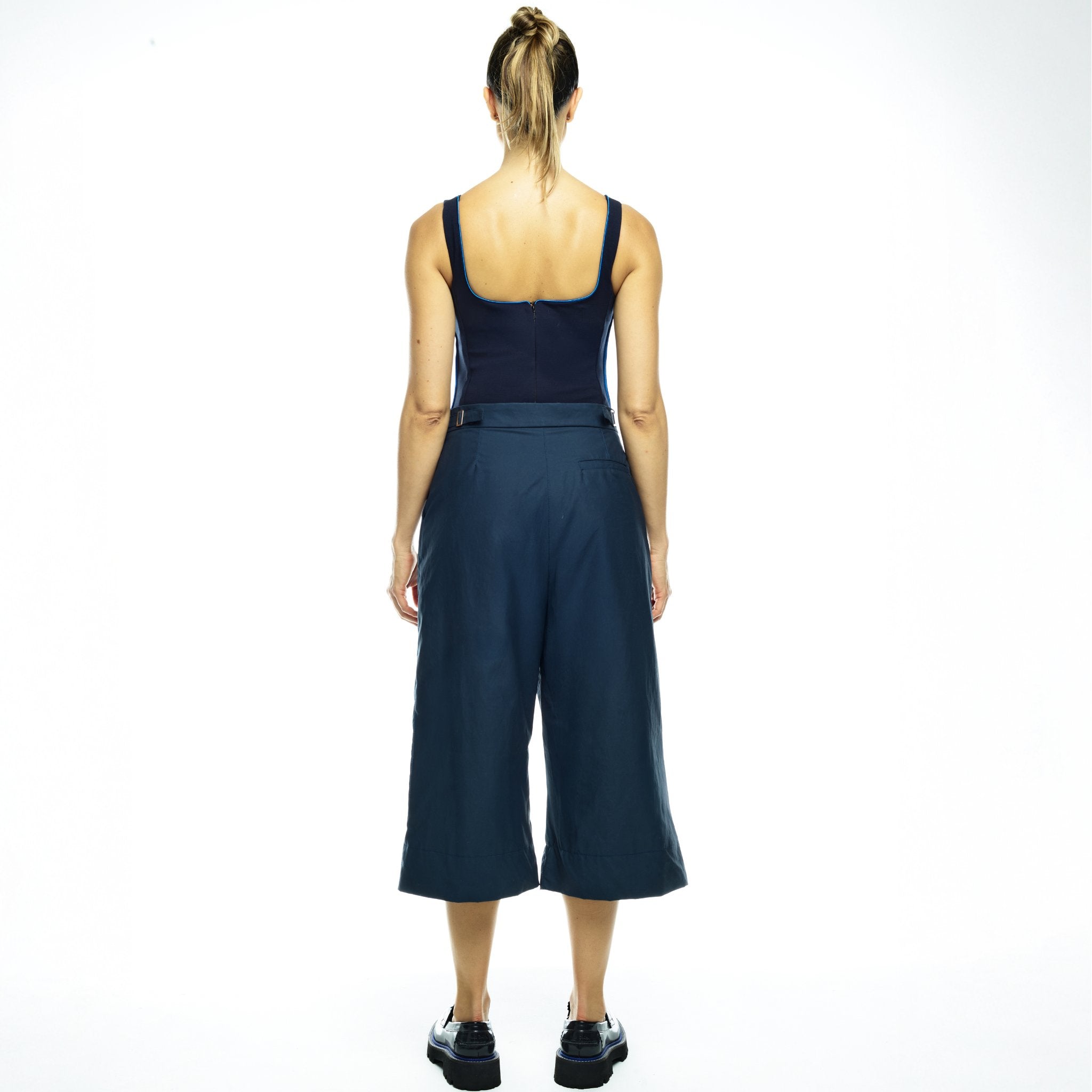 Woman wearing a navy outfit with white background