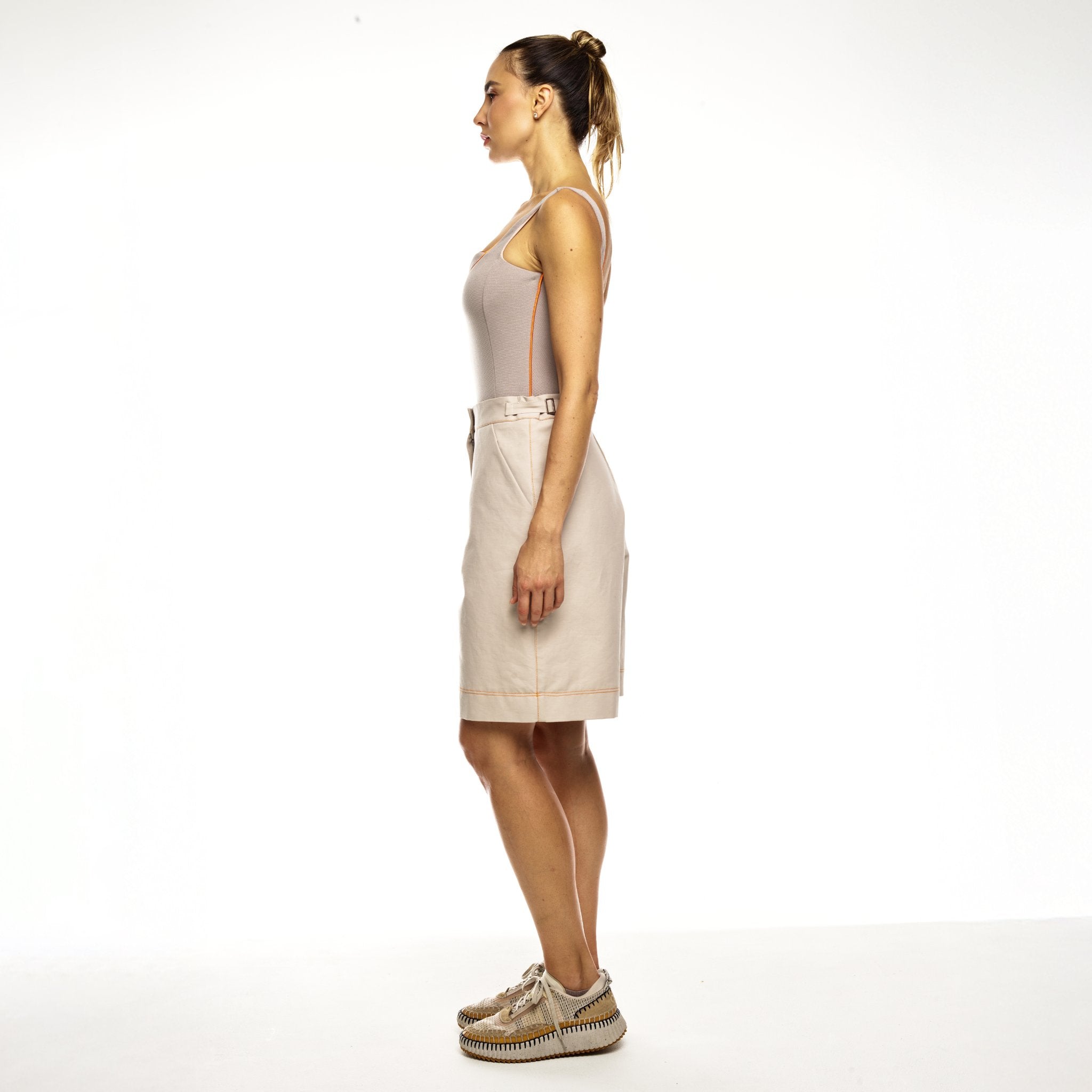Woman wearing beige bermudas white background