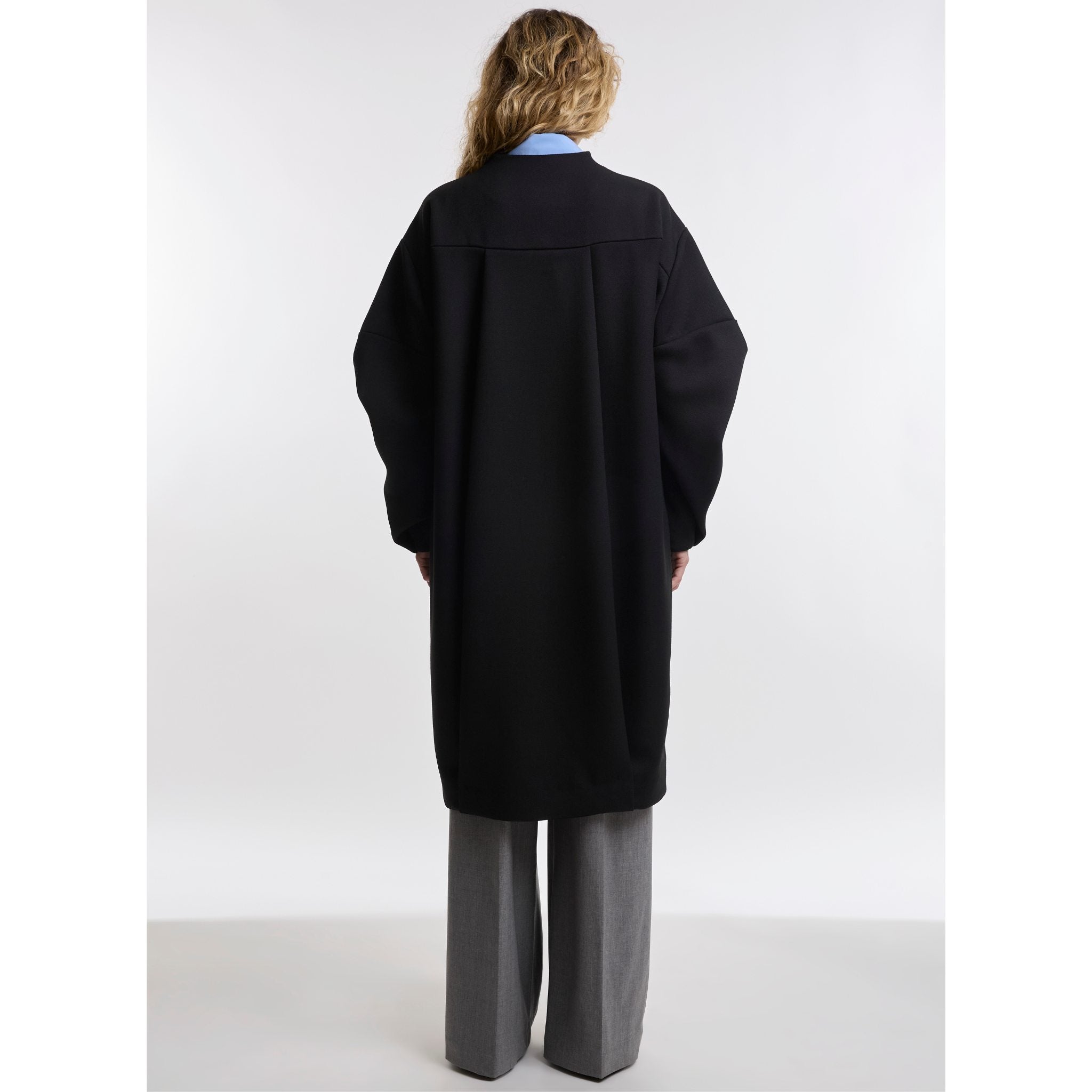 Woman wearing a black coat on white background