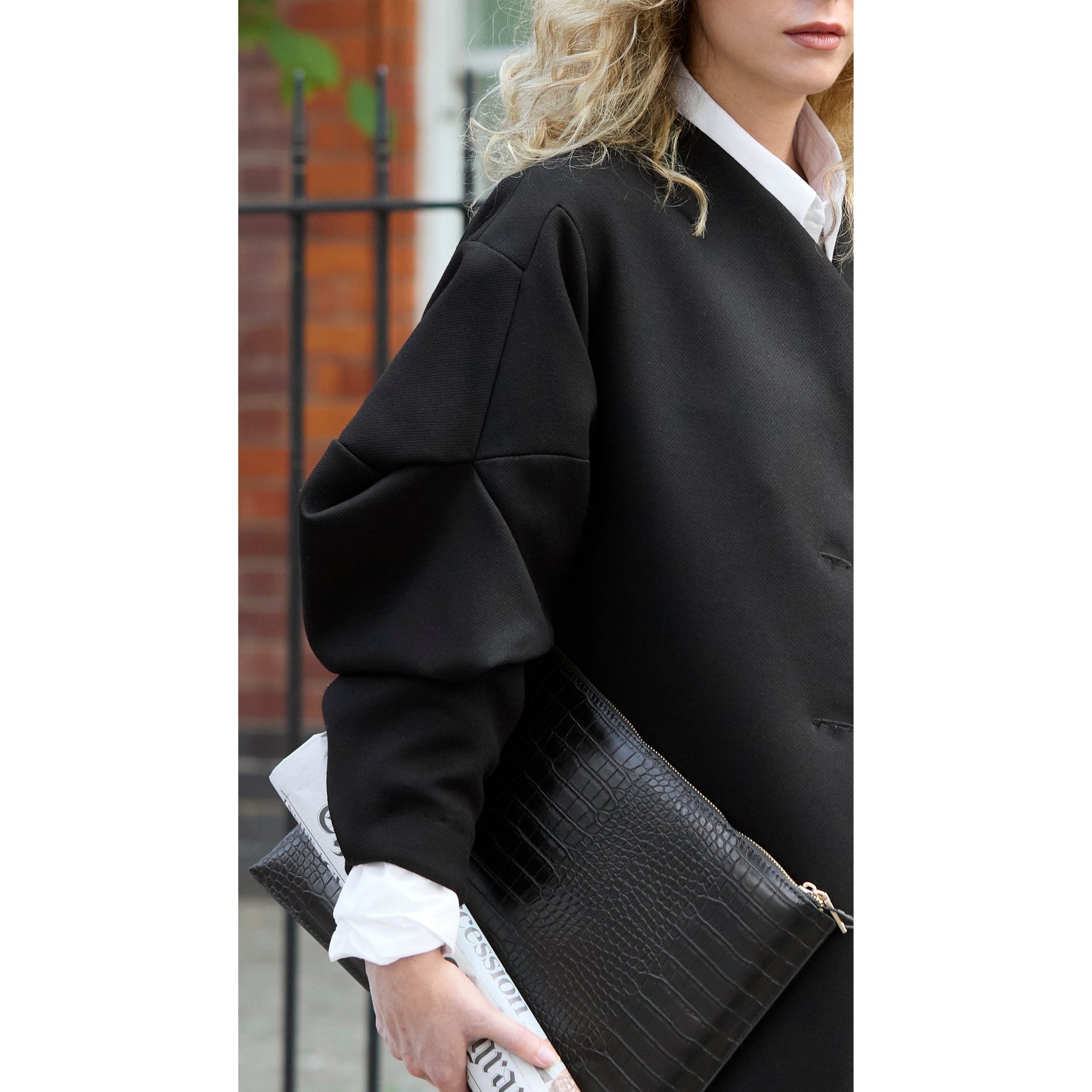Person wearing black coat holding a briefcase