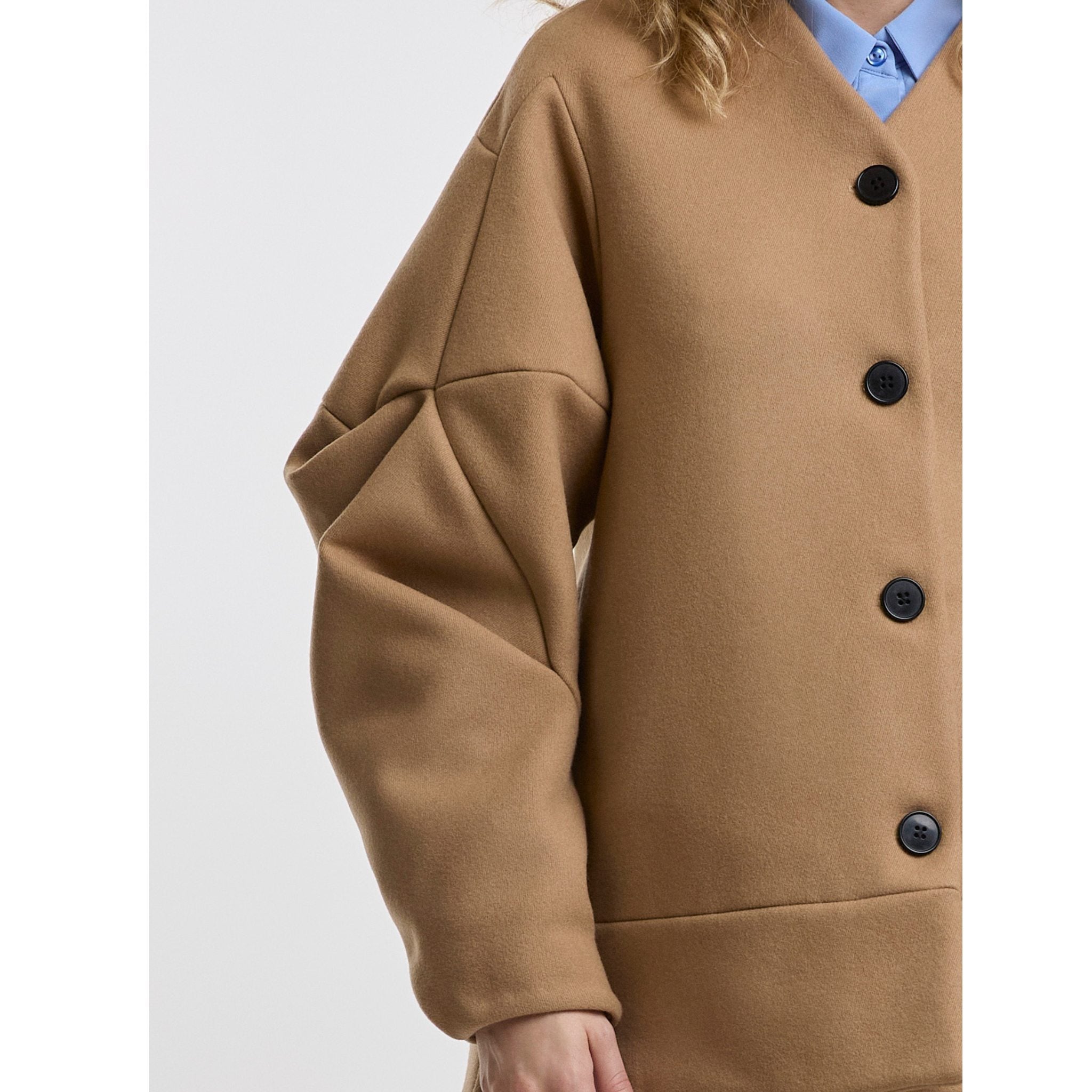 Camel coat with black buttons on a white background