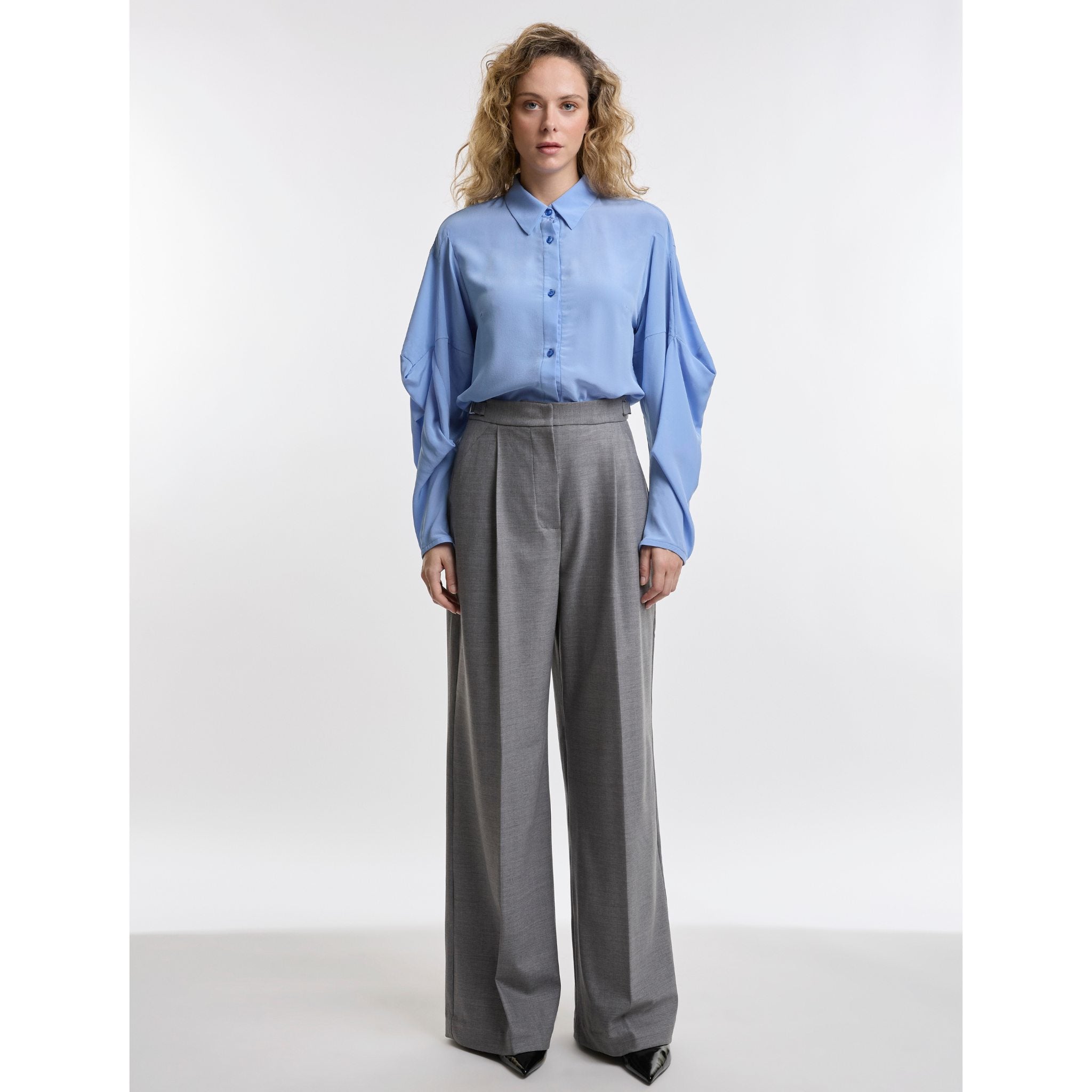 Wman wear grey trousers and blue shirt