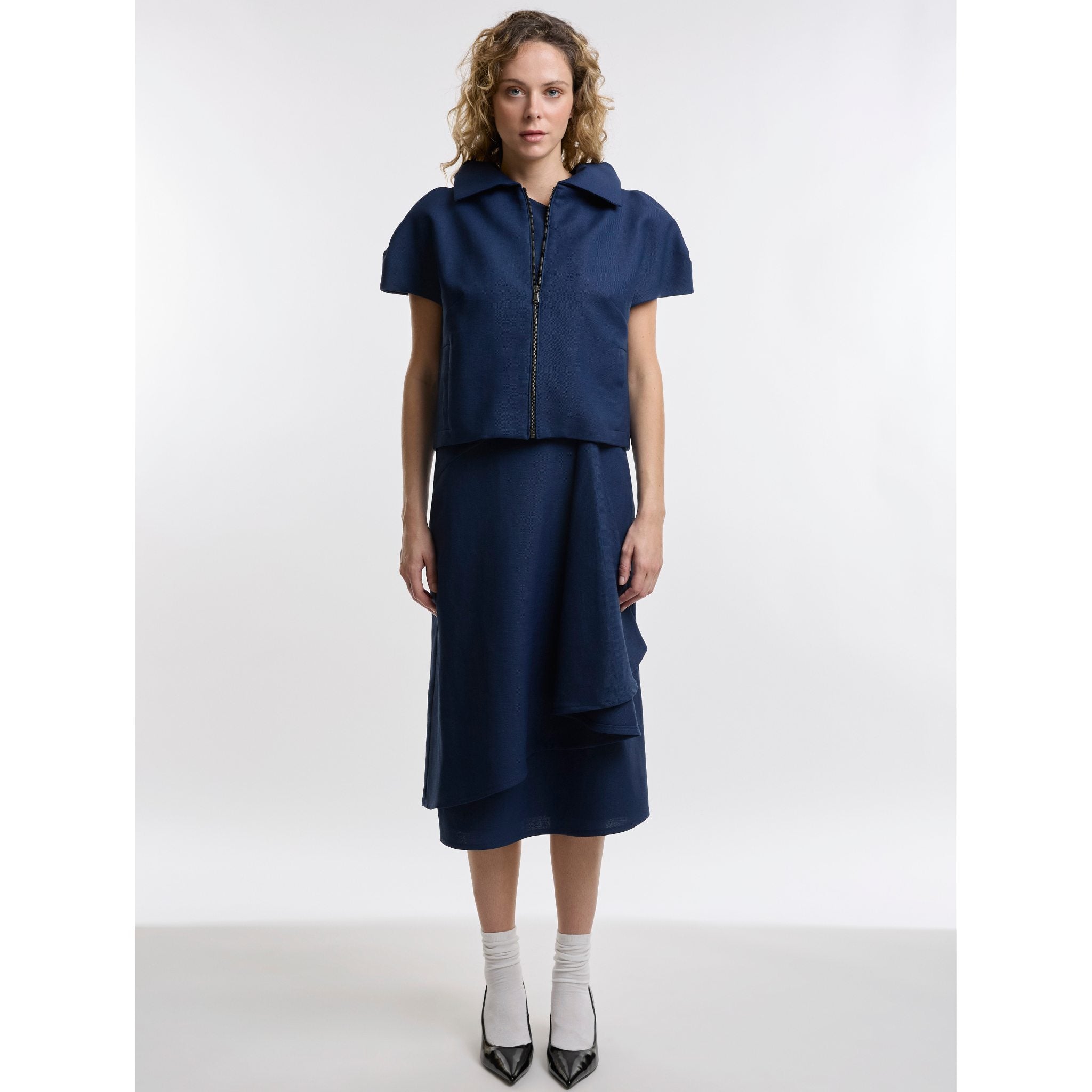 Woman wearing a navy blue outfit with a white background