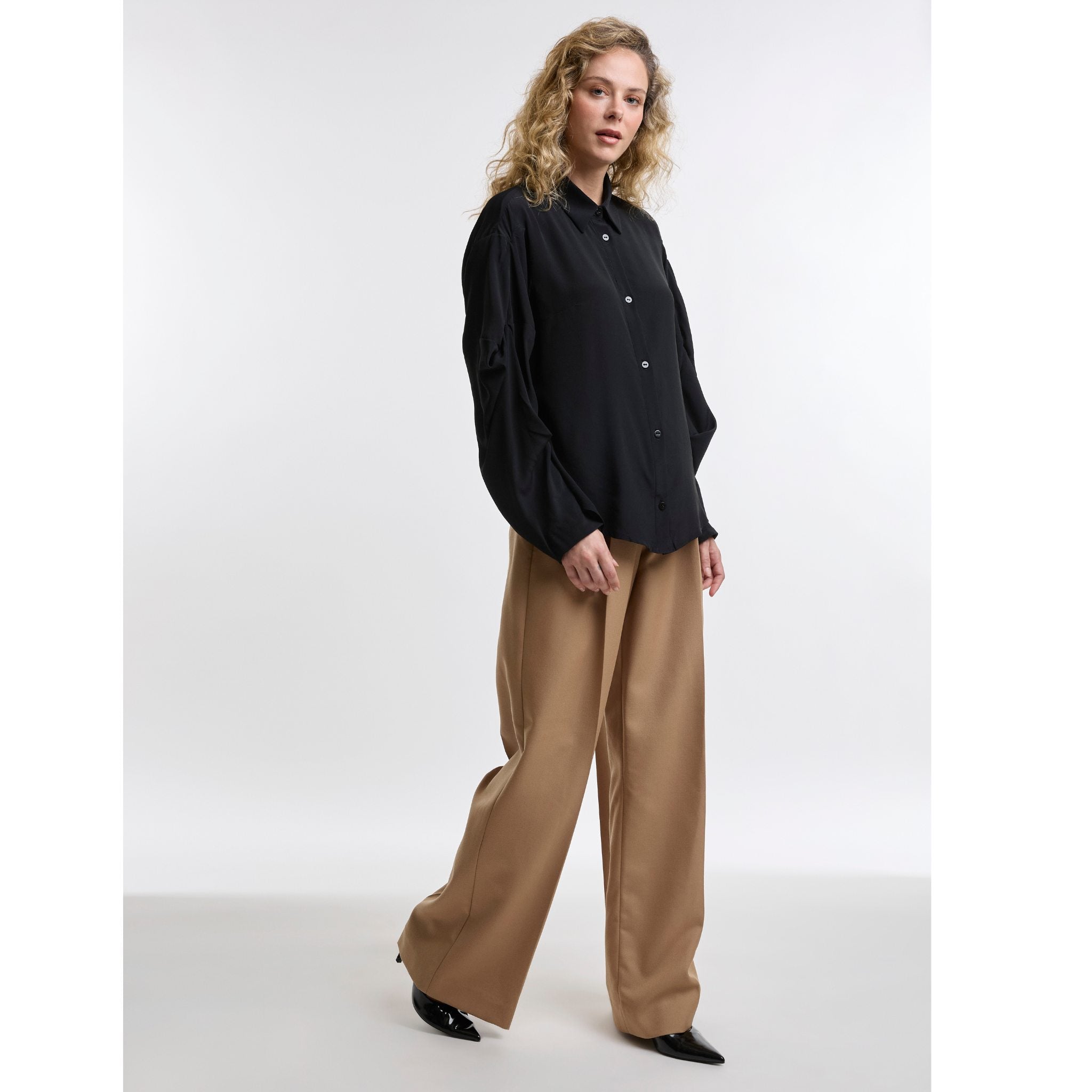 woman wearing a black shirt with camel trousers